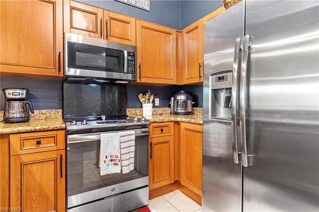 a kitchen with stainless steel appliances granite countertop a refrigerator stove and microwave