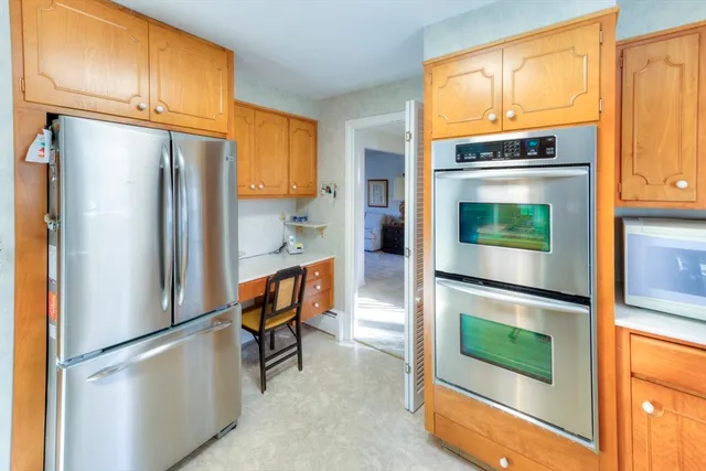 a kitchen with stainless steel appliances granite countertop a refrigerator and a stove top oven