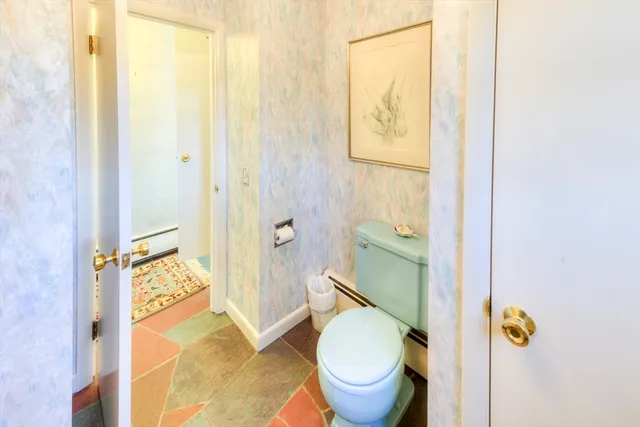 a bathroom with a granite countertop toilet and a sink