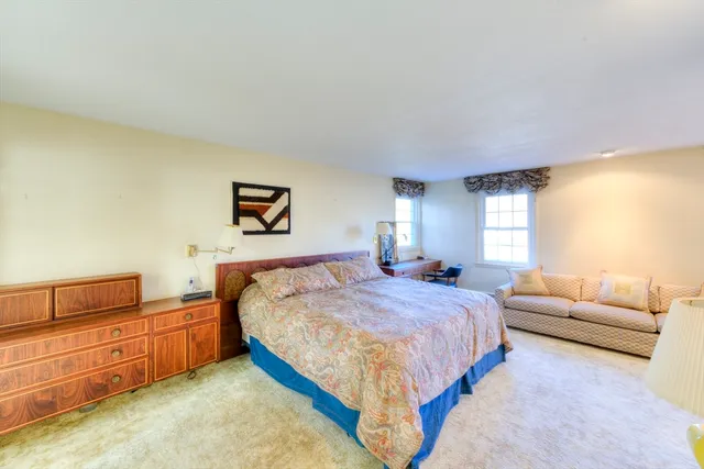 a bedroom with a bed couch and window