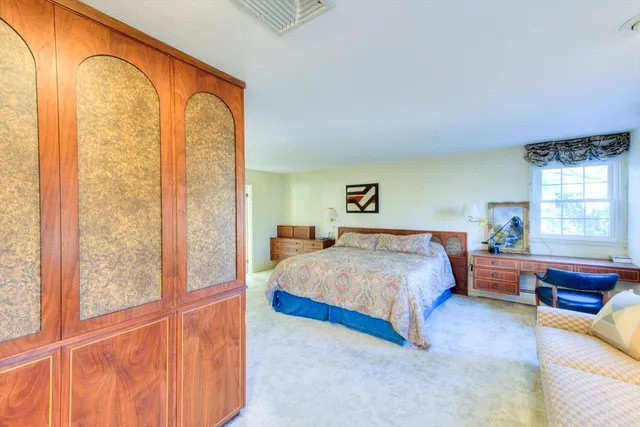 a bed sitting in a bedroom next to a window