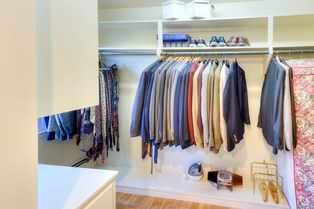a view of walk in closet with clothes and shoes
