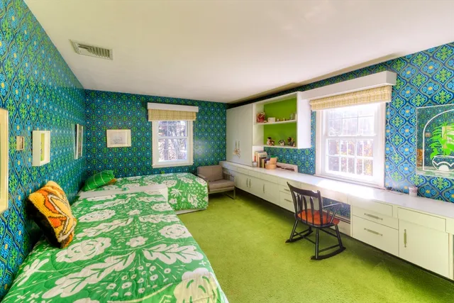 a bedroom with a bed chair and a large window