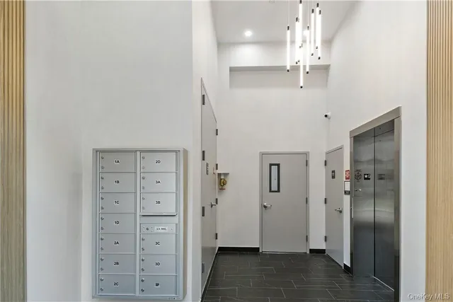a view of a hallway with wooden floor and chandelier