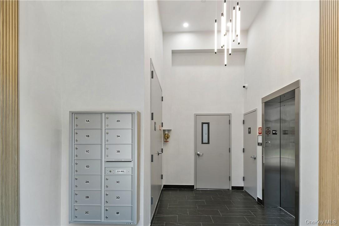 348 Main Street, Unit 3C New Rochelle, NY 10801 - Photo 3 of 14 a view of a hallway with wooden floor and chandelier