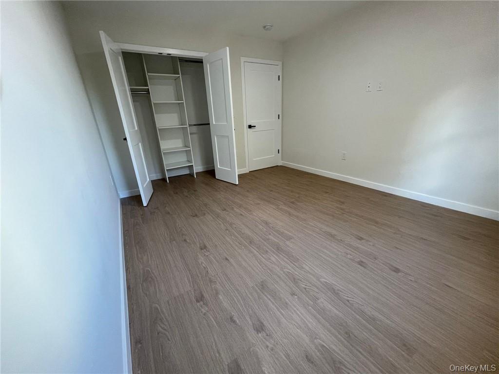 348 Main Street, Unit 3C New Rochelle, NY 10801 - Photo 9 of 14 an empty room with wooden floor and white doors