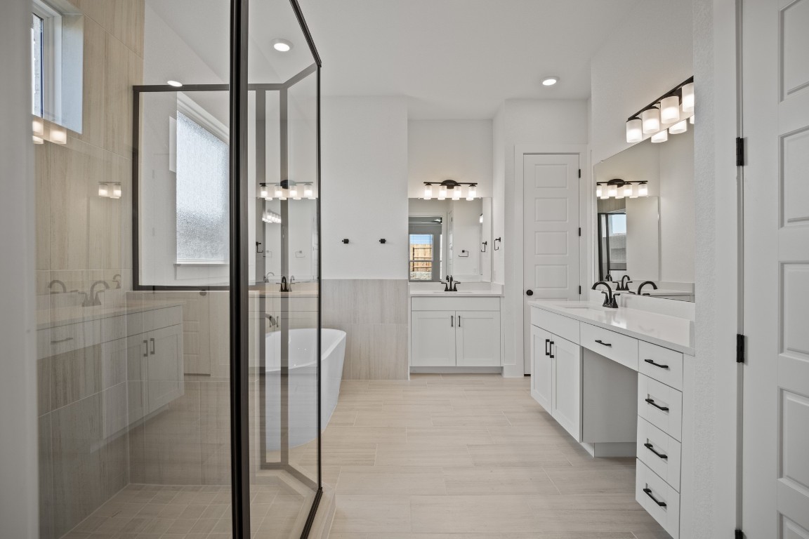 245 Begonia Street Buda, TX 78610 - Photo 12 of 21 a spacious bathroom with a double vanity sink a mirror and a shower