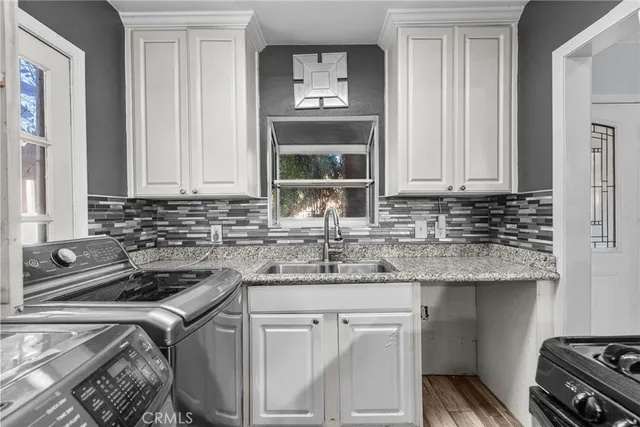 a kitchen with stainless steel appliances granite countertop a sink stove and cabinets
