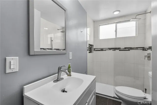 a bathroom with a sink a toilet and shower