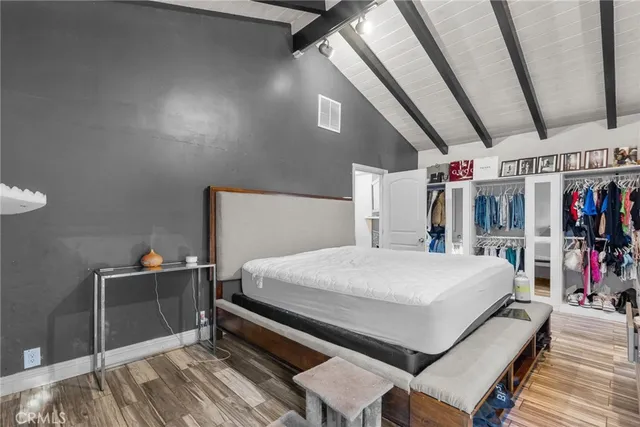 a bedroom with a bed and a large mirror on the dresser