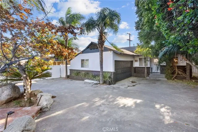 a white house that has a tree in front of it