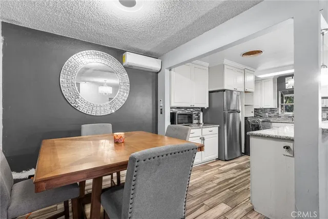 a kitchen with refrigerator and chairs