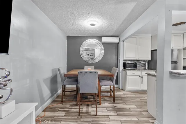 a view of a dining room and kitchen with furniture a rug and wooden floor