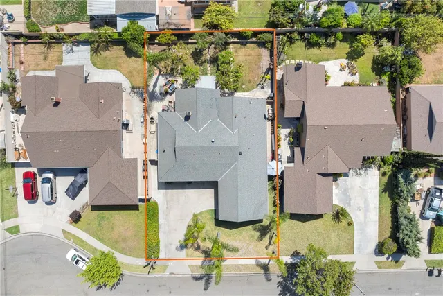 an aerial view of residential houses with outdoor space and parking