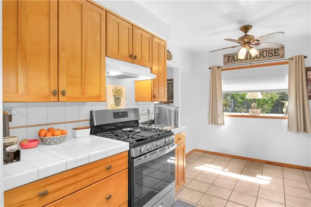 a kitchen with stainless steel appliances a stove a sink cabinets and a window