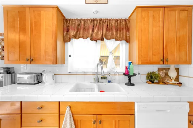 a kitchen with a sink a window and cabinets