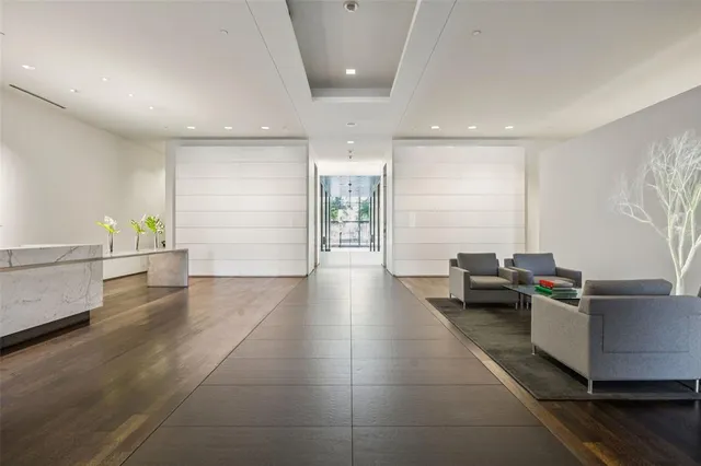 a living room with couches and kitchen view with wooden floor