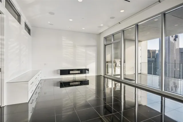 a view of a hall with a ceiling fan and window