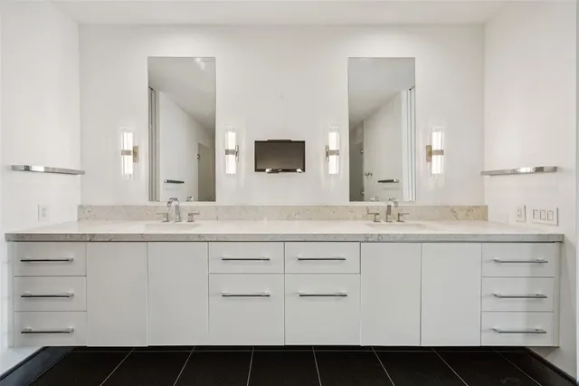 a bathroom with a double vanity sink a toilet and shower