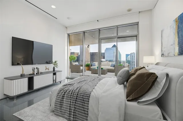 a bedroom with a bed and a flat screen tv on dresser
