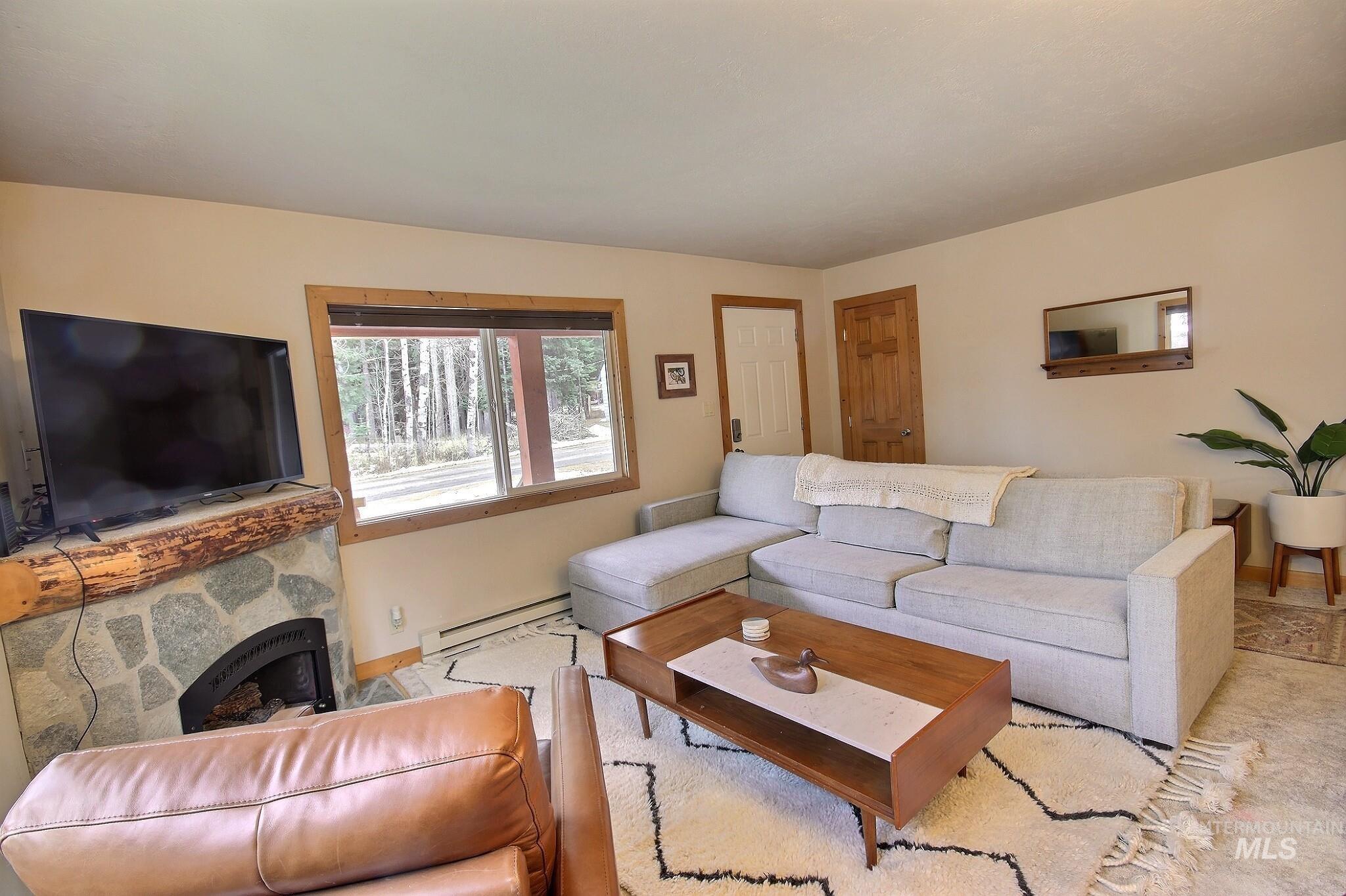 1000 Gamble Road McCall, ID 83638 - Photo 4 of 15 Living room with a baseboard radiator and a fireplace
