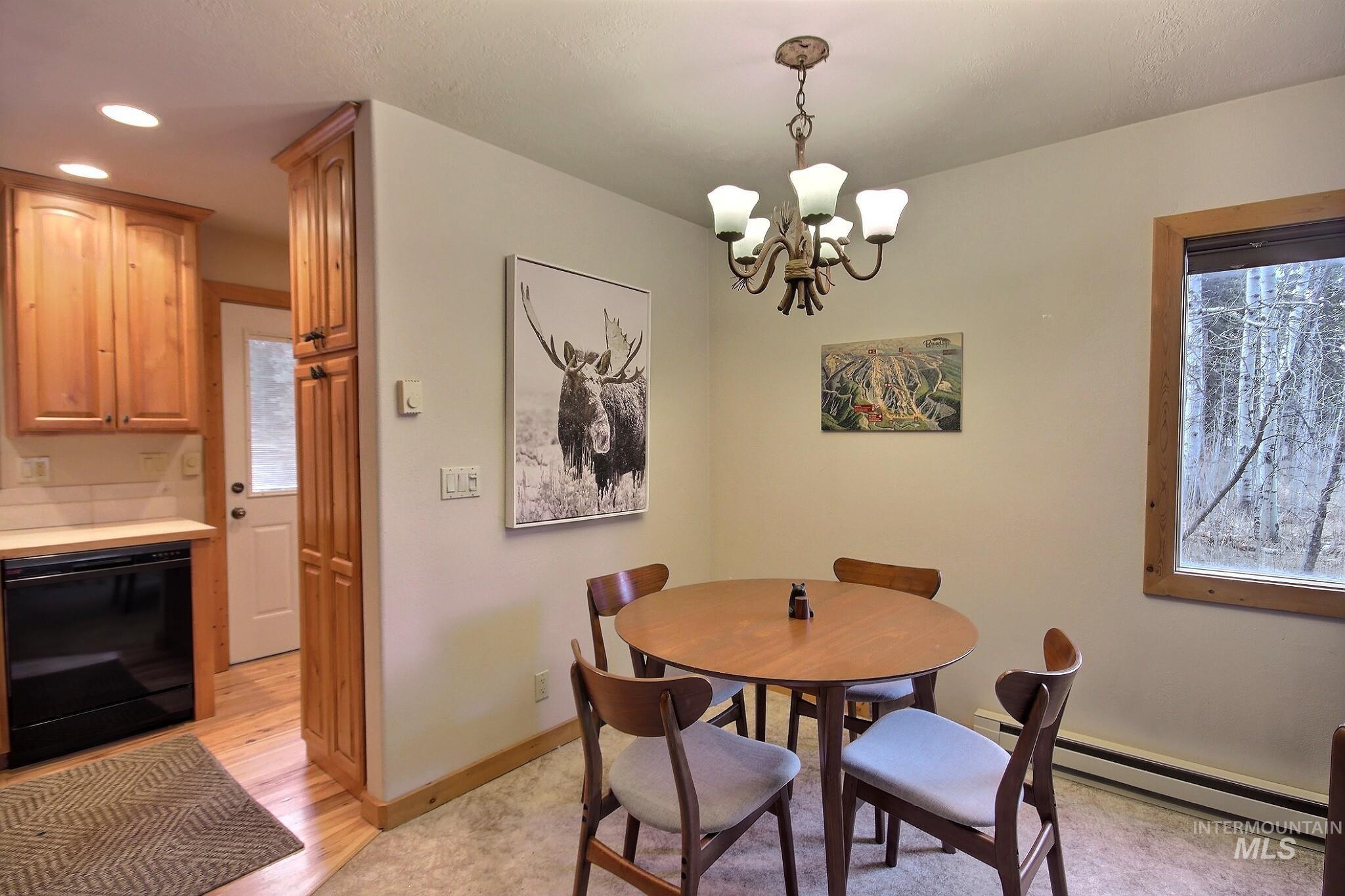 1000 Gamble Road McCall, ID 83638 - Photo 7 of 15 Dining room with baseboard heating, a chandelier, and light wood-type flooring