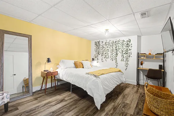 a bedroom with a bed a chair and potted plant