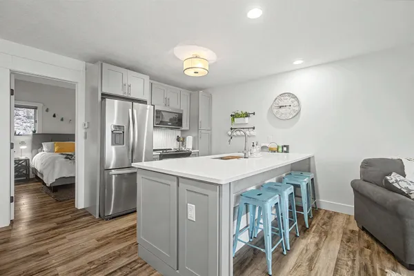 a kitchen that has a lot of cabinets a sink and wooden floor
