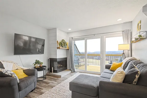 a living room with furniture a flat screen tv and a large window