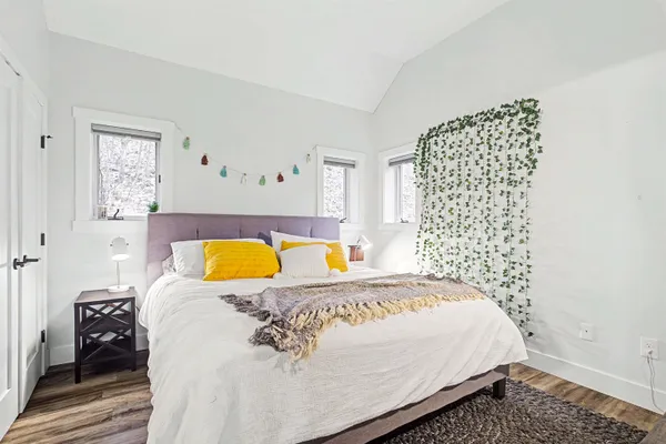 a bed sitting in a bedroom next to a lamp