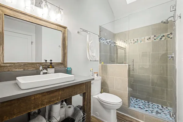 a bathroom with a sink toilet a mirror and shower