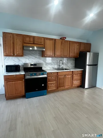 a kitchen with stainless steel appliances a stove a sink and a refrigerator