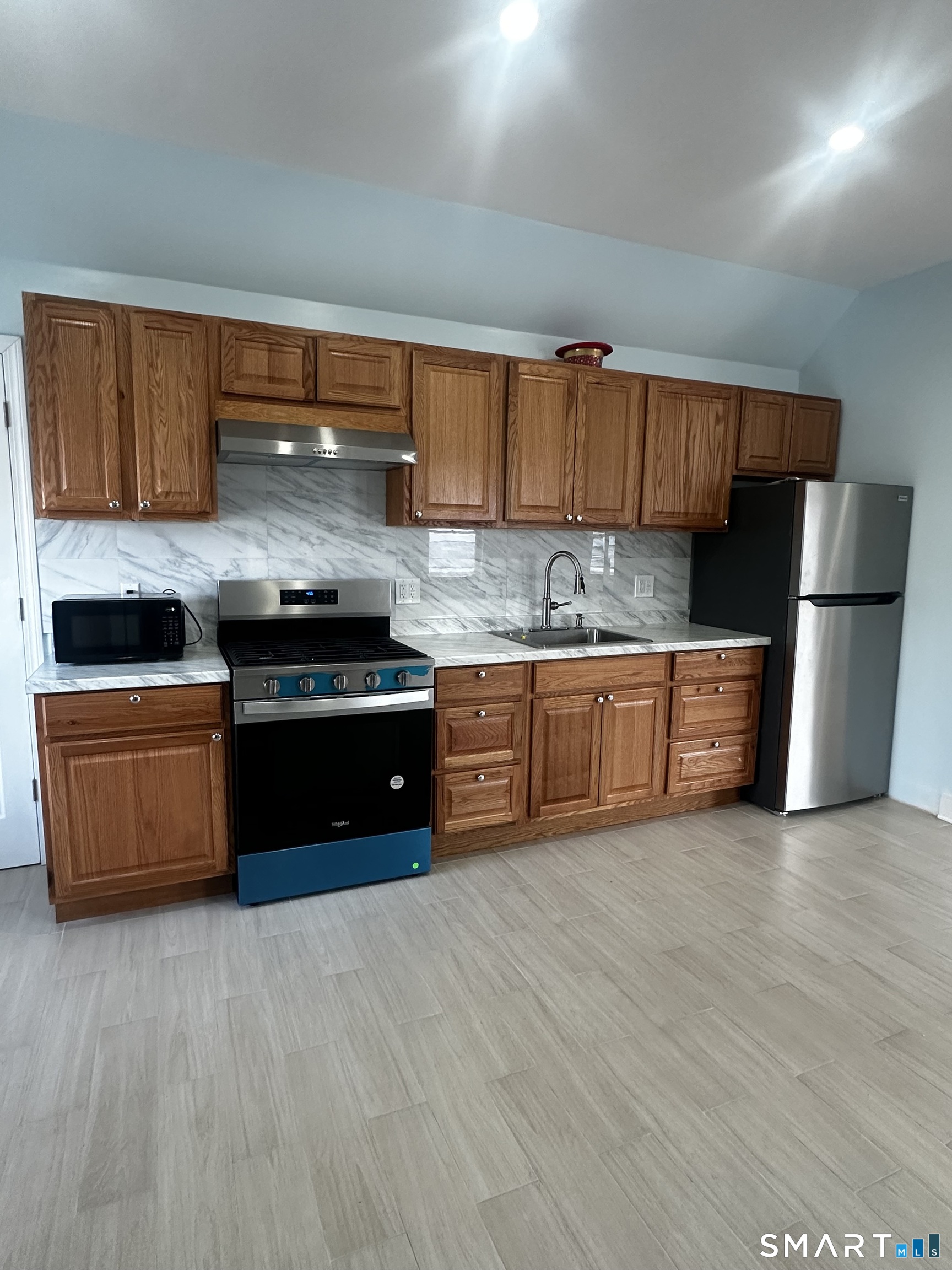 185 Alpine Street, Unit 3 Bridgeport, CT 06610 - Photo 2 of 7 a kitchen with stainless steel appliances a stove a sink and a refrigerator