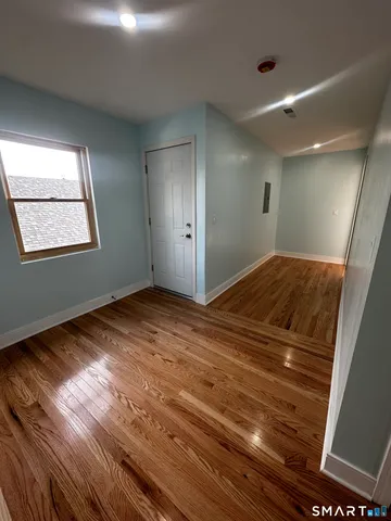 a view of empty room with wooden floor
