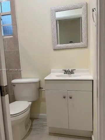 a bathroom with a sink a toilet and mirror