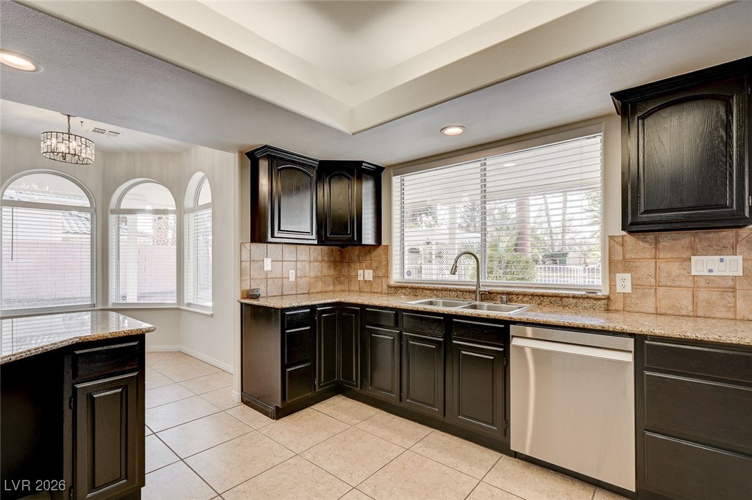 2955 El Camino Road Las Vegas, NV 89146 - Photo 29 of 99 Kitchen with stainless steel dishwasher, light stone counters, light tile patterned floors, backsplash, and recessed lighting