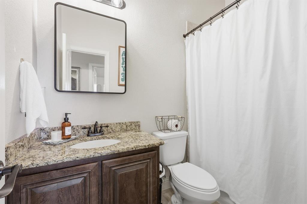 324 Sherbrook Street Van Alstyne, TX 75495 - Photo 22 of 27 a bathroom with a granite countertop sink mirror vanity and toilet
