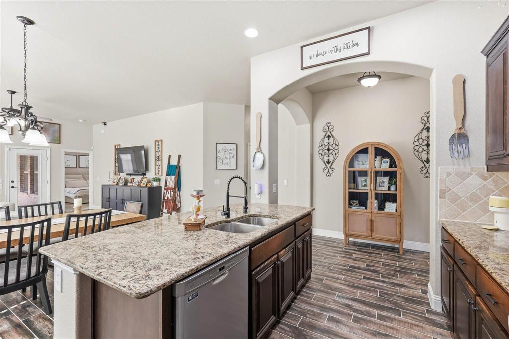 324 Sherbrook Street Van Alstyne, TX 75495 - Photo 8 of 27 a bathroom with a granite countertop sink a large mirror and a wooden floor