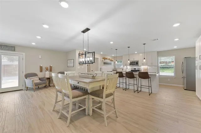 a large kitchen with kitchen island a large counter top space a sink stainless steel appliances and cabinets