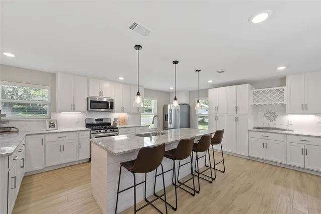 a kitchen with stainless steel appliances kitchen island granite countertop a sink and cabinets