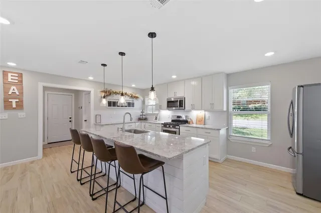 a kitchen with appliances cabinets and wooden floor