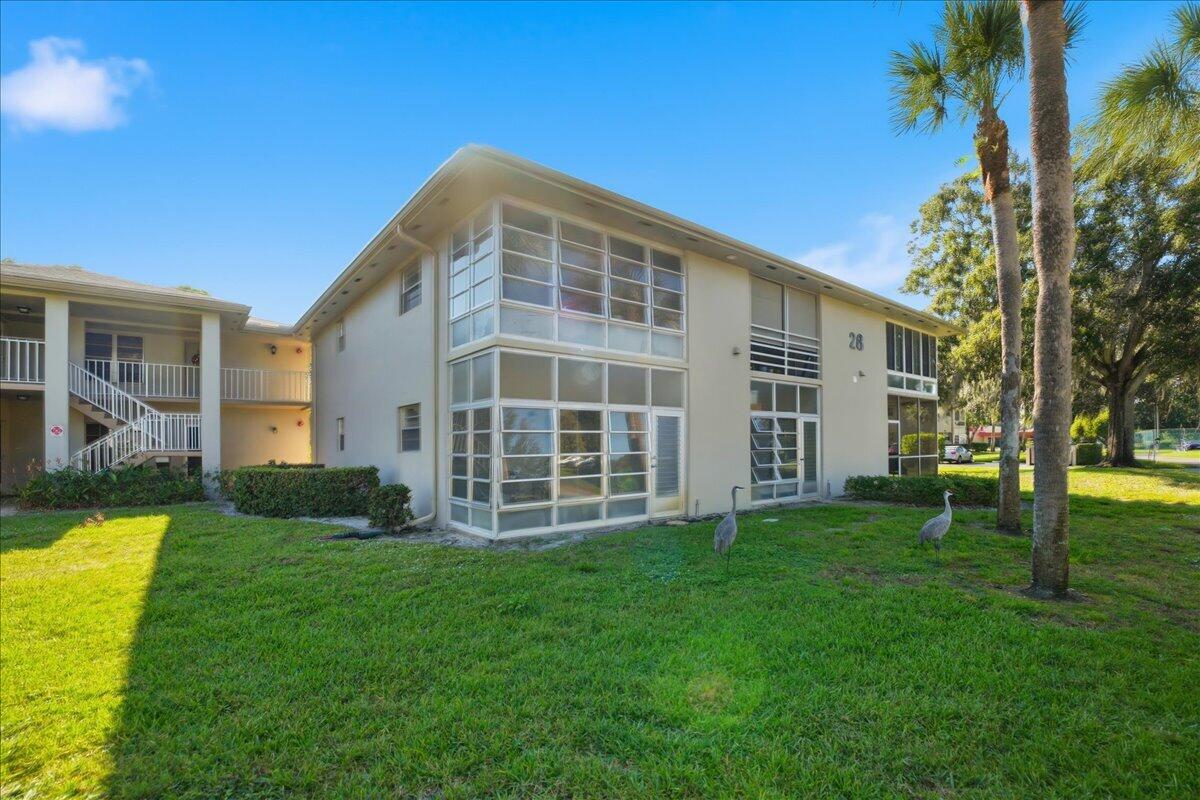 28 Lake Vista Trail, Unit 105 Port St. Lucie, FL 34952 - Photo 18 of 26 a front view of a house with a yard