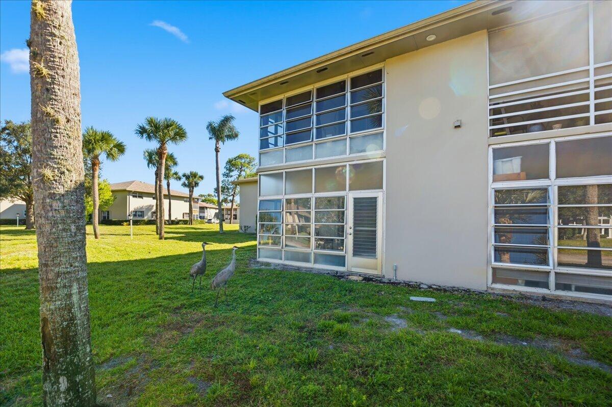 28 Lake Vista Trail, Unit 105 Port St. Lucie, FL 34952 - Photo 19 of 26 a view of a house with a swimming pool and a yard