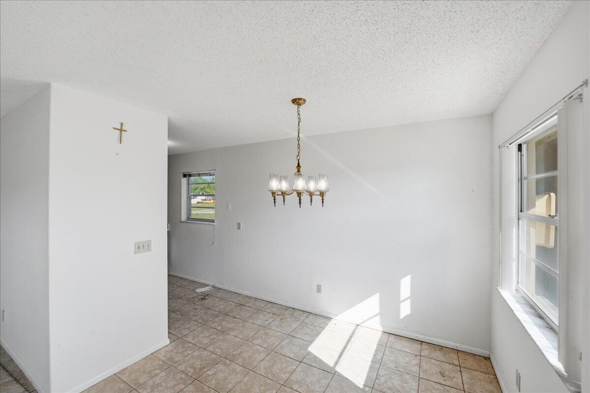 28 Lake Vista Trail, Unit 105 Port St. Lucie, FL 34952 - Photo 5 of 26 a view of a hallway with chandelier and entryway