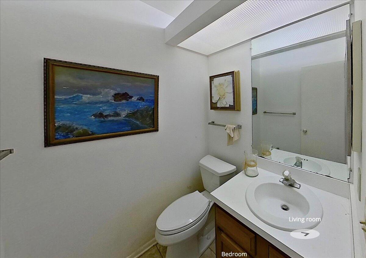 28 Lake Vista Trail, Unit 105 Port St. Lucie, FL 34952 - Photo 10 of 26 a bathroom with a toilet a sink and mirror