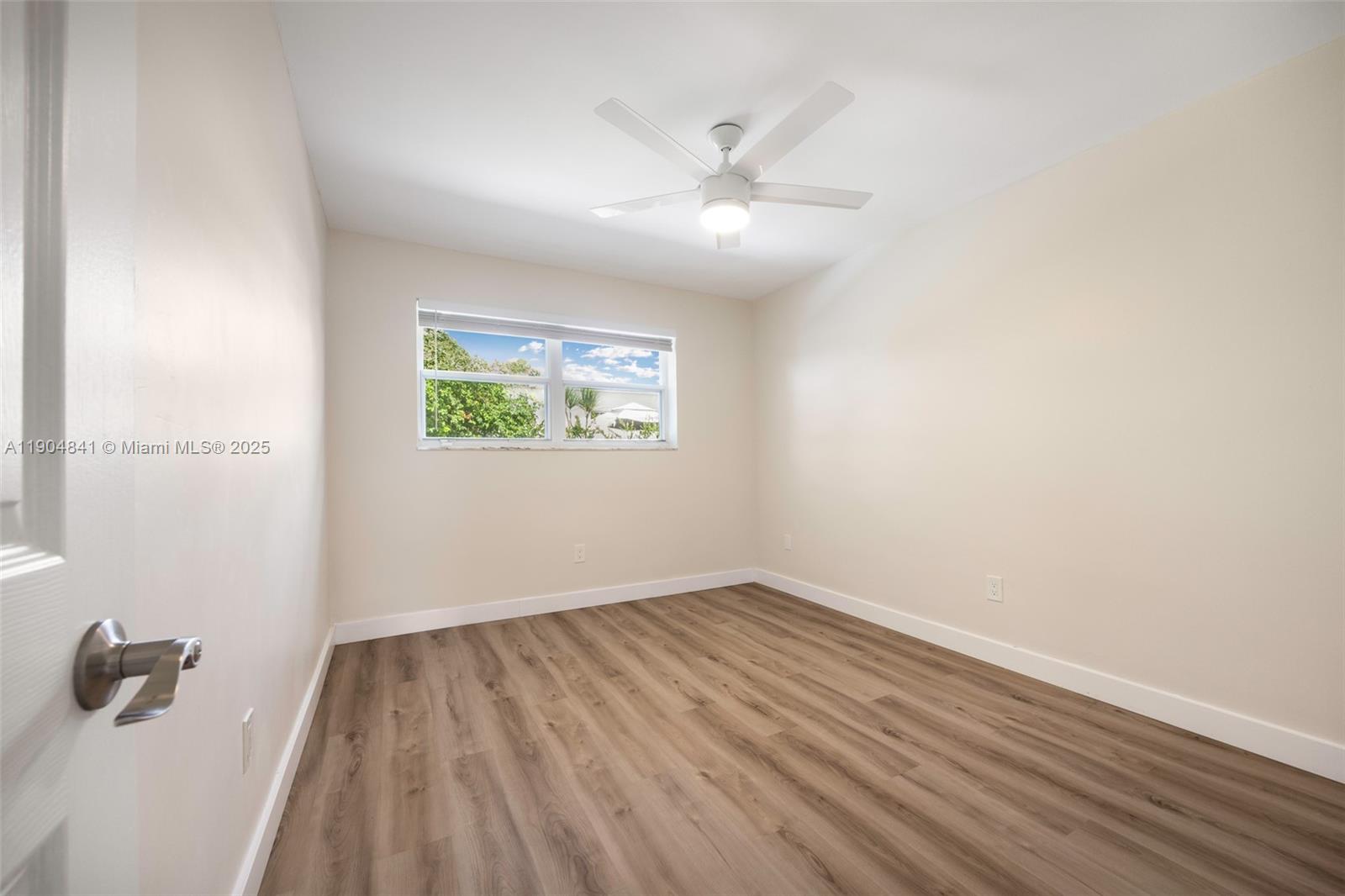 3101 Southwest 19th Street, Unit 3101 Miami, FL 33145 - Photo 11 of 15 an empty room with wooden floor ceiling fan and windows