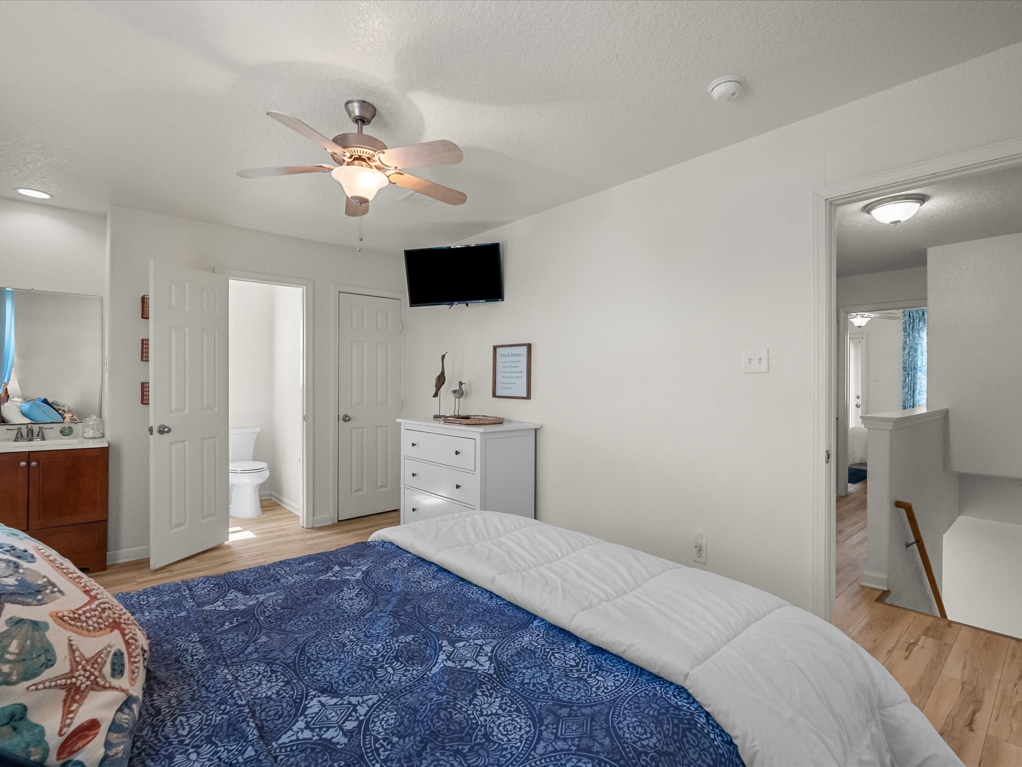 127 Howard Avenue Surfside Beach, TX 77541 - Photo 17 of 29 a bedroom with a large bed and a chandelier