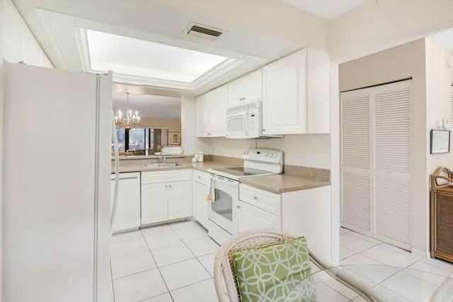 a kitchen with a dining table chairs and a refrigerator