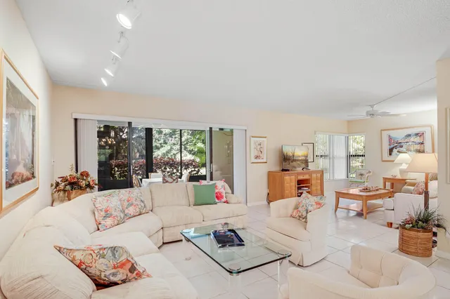 a living room with furniture and a dining table with wooden floor