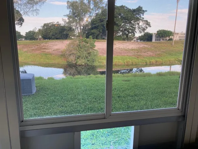a view of backyard with large windows and floor to ceiling window
